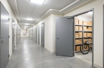 Светлый подвальный коридор многоквартирного дома с дверями кладовых жильцов